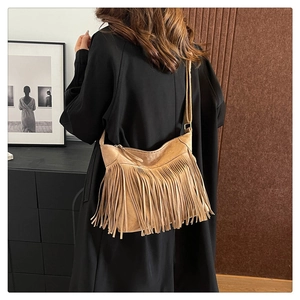 Detail of camel faux suede tote bag featuring long fringes and adjustable wide strap