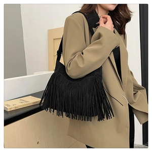 Detail of black fringe shoulder bag with long flowing tassels in a boho-chic style
