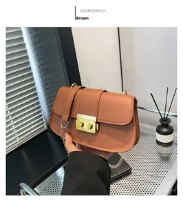 Détail du sac en cuir grainé marron avec boucle rectangulaire dorée élégante