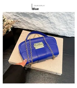 Détail du sac en cuir bleu roi avec coutures verticales et chaîne en métal doré