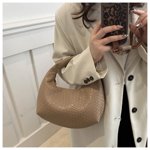 Detail of woven khaki hobo bag showing the intricate texture and single top handle design
