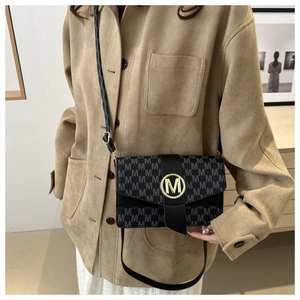 Gros plan d'un sac sous les aisselles avec imprimé M et logo métallique doré chic