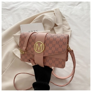 Détail du sac à bandoulière rose avec imprimé M et boucle circulaire en métal doré