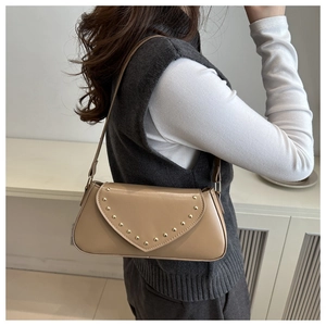 Close-up of vintage rivet detailing on khaki PU leather shoulder baguette bag