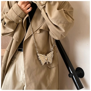 Détail du sac de soirée papillon doré avec strass scintillants et chaîne fine