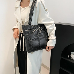 Quilted black puffer tote bag for women with wide shoulder straps in minimalist style