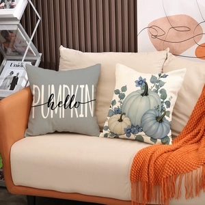 Set di due cuscini decorativi a tema zucca con stampa hello pumpkin su divano in pelle