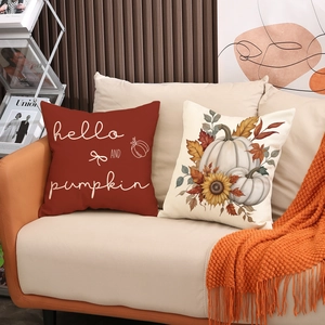 Autumn pumpkin and sunflower print linen pillow covers on a cozy sofa for fall decor