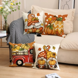 Set of four autumn harvest pillow covers with gnomes and pumpkins on a sofa
