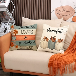 Lot de deux housses de coussin en lin avec motifs d'automne sur un canapé douillet