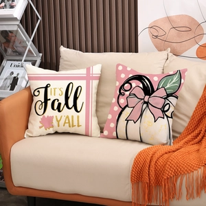 Close-up of fall decorative pillow set with pumpkin and maple leaf patterns on sofa