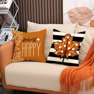 Cuscini decorativi autunnali con foglie di acero e strisce su un divano accogliente