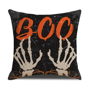 Halloween pillow cover with orange BOO text and skull hands on black linen background