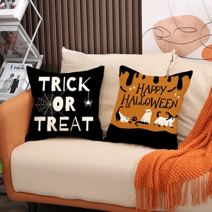 Halloween decorative pillow covers with spider web and cat prints on a cozy sofa