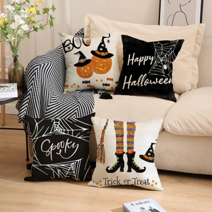 Juego de cuatro fundas de cojín de Halloween con motivos de calabaza y araña en el sofá