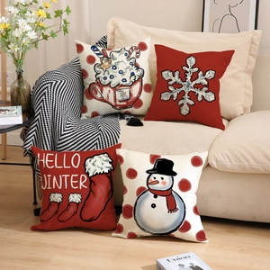 Set of four Christmas snowman cushion covers with Hello Winter lettering on sofa