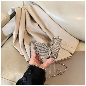 Vue détaillée de la pochette papillon argentée de luxe avec strass et chaîne en métal
