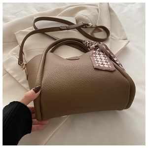 Détail du sac seau marron en cuir grainé avec un foulard décoratif en soie