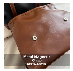 Dettaglio macro della borsa in pelle marrone con chiusure magnetiche in argento lucido