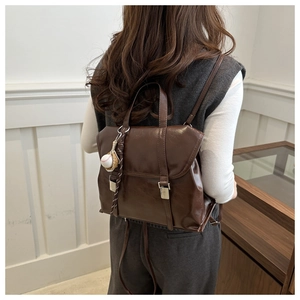 Vue détaillée du sac à dos vintage en similicuir marron avec boucles et pendentif décoratif