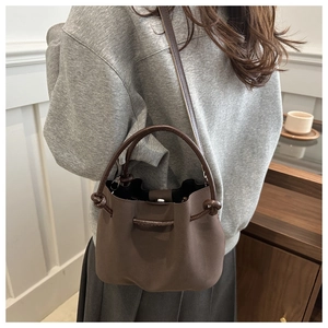 Detail der kaffeebraunen Beuteltasche mit matter Textur und metallischem Magnetverschluss