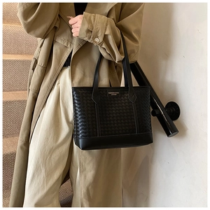 Detailed view of black woven leather tote bag with large capacity and shoulder strap