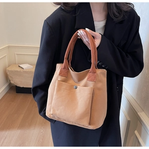 Détail du sac cabas minimaliste en toile avec poignées contrastées et poche à bouton-pression