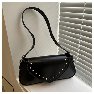 Detail of black vintage PU leather shoulder bag with golden rivets and V-shaped flap