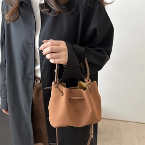 Braune geraffte Beuteltasche mit verstellbarem Gurt im Vintage-Stil an einem Modell