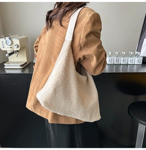 Detail of beige sherpa hobo bag with white leather strap in a retro cafe setting