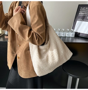 Detail of soft white faux shearling tote bag with premium leather straps on a female model