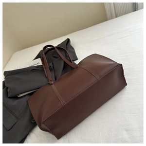 Détails de couture sur un sac cabas en cuir marron foncé au design minimaliste chic