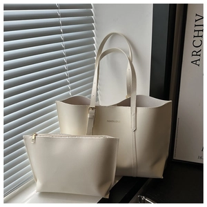 Détail d'un ensemble cabas beige minimaliste avec boucles réglables et logo doré
