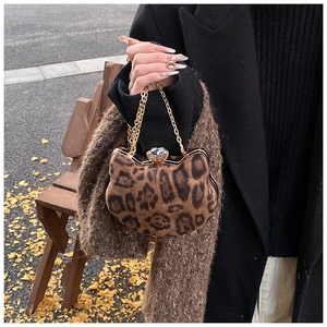 Close-up of leopard print cat-shaped mini bag with gold chain and rhinestone lock