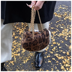 Detail of leopard print plush cat-shaped bag with crystal clasp and gold chain strap