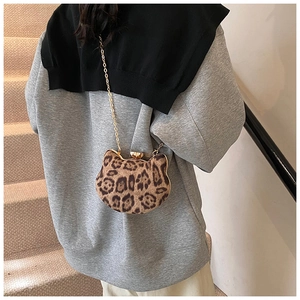 Chic leopard print cat-shaped mini crossbody bag with gold chain strap on a model