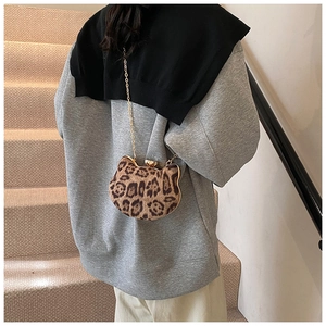 Chic leopard print cat-shaped mini bag with golden chain strap on a lifestyle model