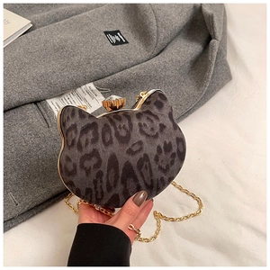 Detail of leopard print cat-shaped mini bag with gold chain and jewel clasp on coat