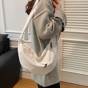Minimalist white nylon crescent crossbody bag with black zipper detail for casual wear