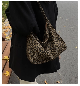 Detail of leopard print tote bag worn by a model in an outdoor autumn setting
