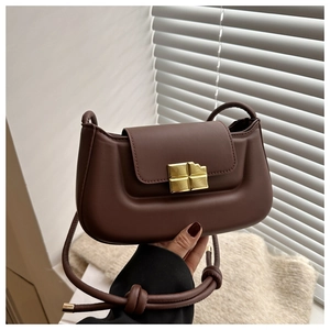 Detail of dark brown PU leather half-moon bag with gold chocolate-shaped metal lock