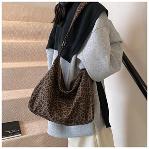 Detail of leopard print canvas tote bag on stairs showing its large hobo style shape