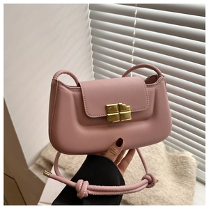 Detailed close-up of pink crossbody bag with a gold chocolate-shaped metal clasp