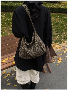 Outdoor street style view of a large leopard print tote bag worn by a model in autumn