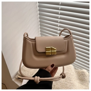 Close-up of vintage beige shoulder bag with unique gold chocolate-shaped metal buckle