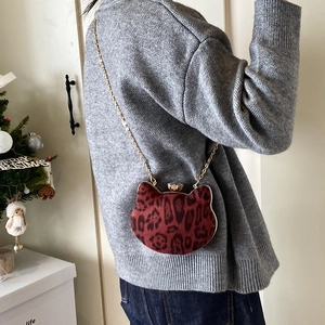 Mini cat-shaped crossbody bag with leopard print and gold chain strap on a gray sweater
