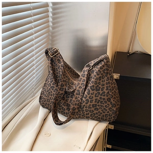 Detail of leopard print hobo bag showing zip closure and adjustable strap on a coat