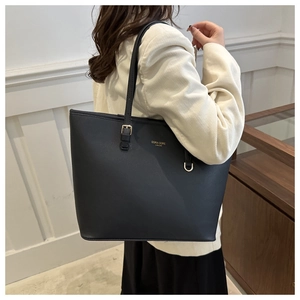 Detail of a black large capacity tote bag worn by a model to show texture and scale