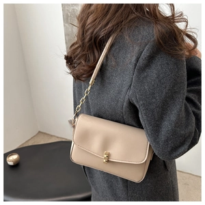 Gros plan du sac à bandoulière en cuir beige avec chaîne dorée et boucle carrée