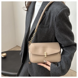 Détail du sac beige avec boucle dorée carrée et bandoulière en chaîne et cuir
